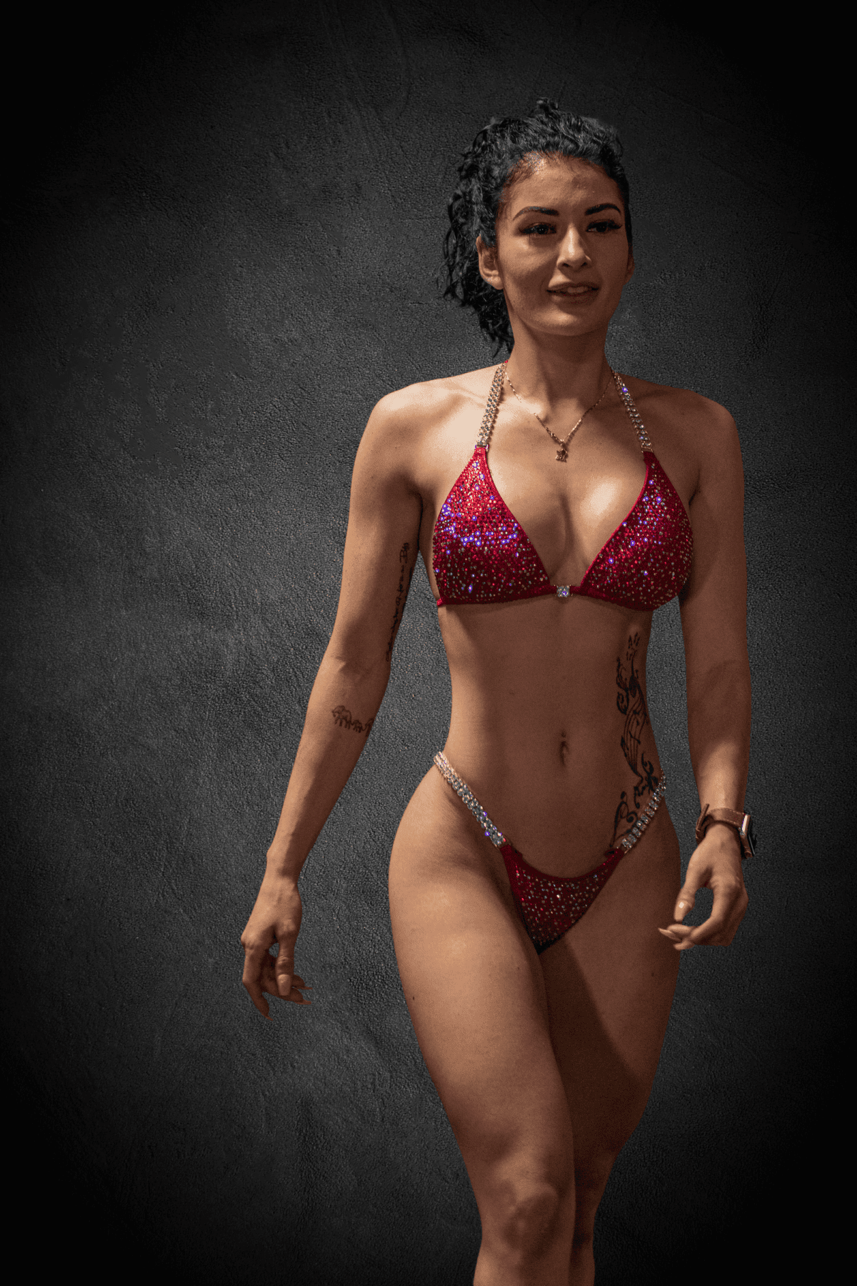 Cynthia poses facing the camera in a red rhinestone bikini.