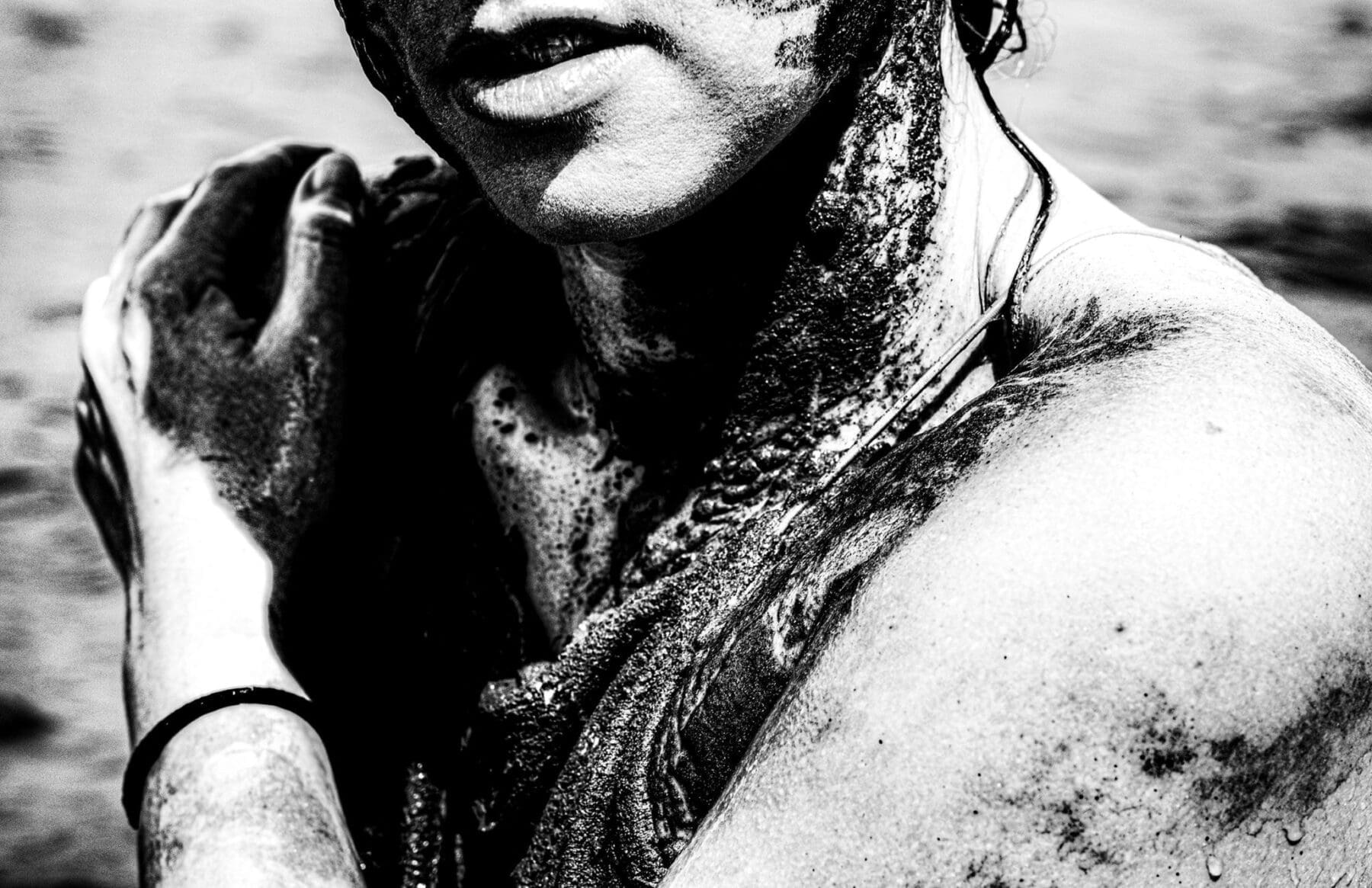 A high-contrast black-and-white conceptual portrait from Katie's Art Side series shows a tight crop of Katie's clasped hands, lips, shoulder, and neck marked with dark material.