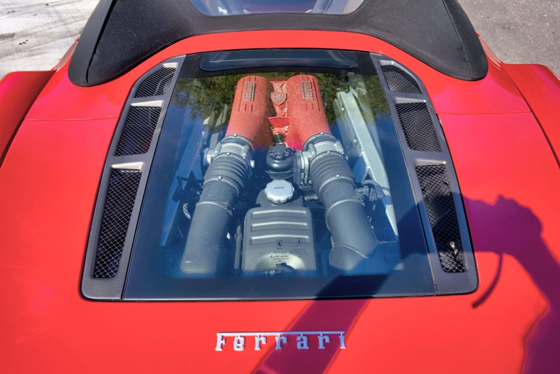 Ferrari F430 engine visible beneath the rear glass cover with Ferrari lettering