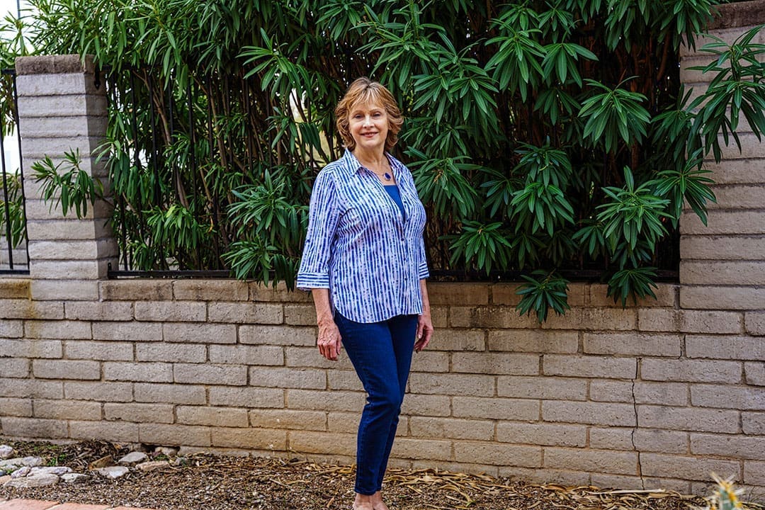 An outdoor environmental portrait of Kate against dense greenery.